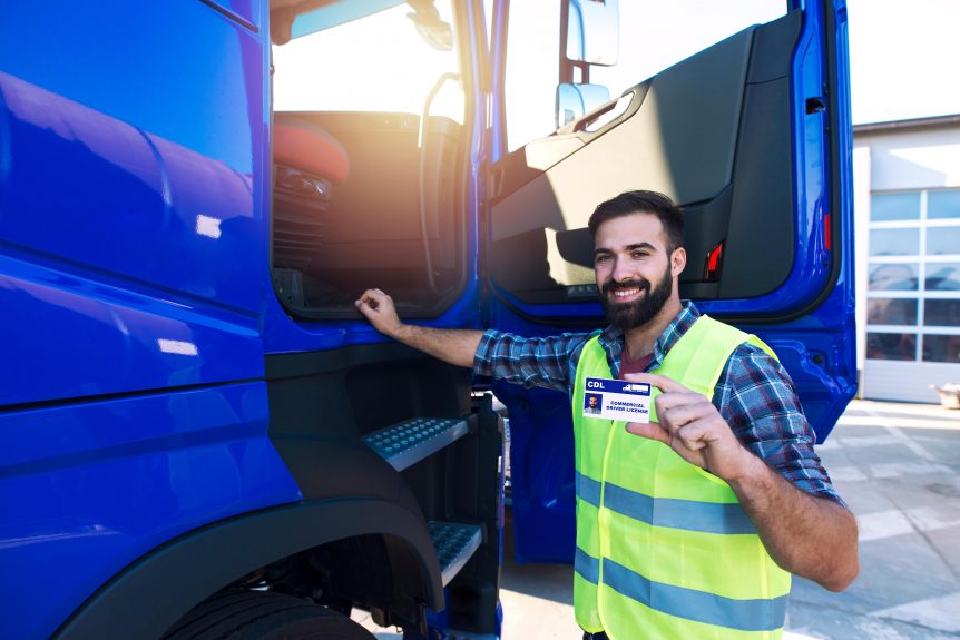 man hold driving licence in front of lorry